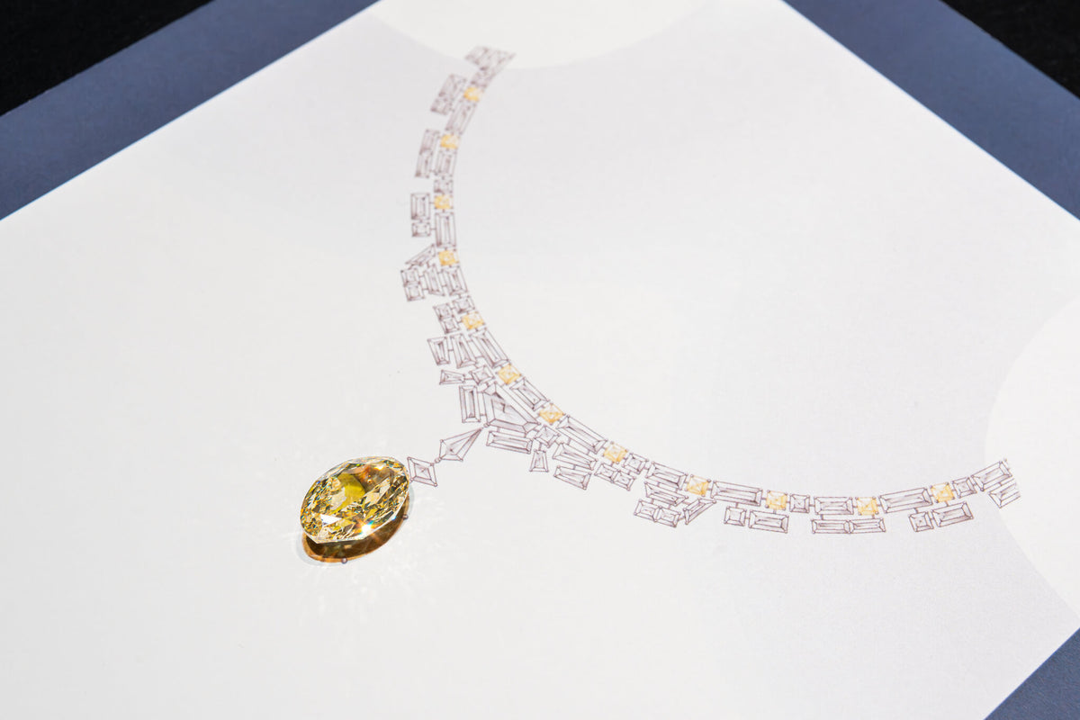Diamond necklace with a yellow gemstone on a white background